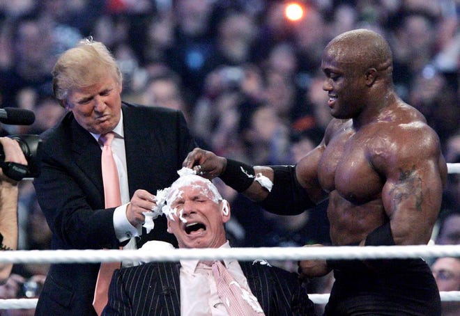 In this April 1, 2007, photo, Donald Trump, left, and Bobby Lashley shave the head of Vince McMahon after Lashley defeated Umaga at Wrestlemania 23 at Ford Field in Detroit. Wrestling aficionados say President Trump, who has a long history with the game, has borrowed tactics of the sport to cultivate the ultimate antihero character -- who wins at all costs, incites outrage and follows nobody's rules but his own. (AP Photo/Carlos Osorio, File)