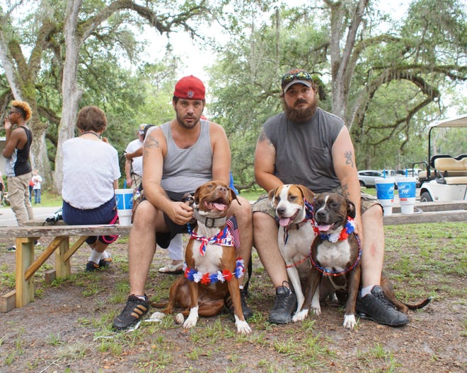 The patriotic-themed pet parade is one attraction at the Fun Day, so brothers Corey Cassels, left, and Carl Cassels, have come with their dogs: Bear, left, and Bear's daughters Sassy, middle, and Elsa. [LINDA CHARLTON / CORRESPONDENT]