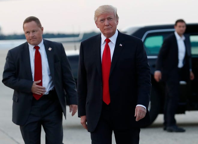 President Donald Trump walks to his motorcade vehicle Monday after he arrives on Air Force One in Andrews Air Force Base, Md., en route to Washington as he returns from Trump National Golf Club in Bedminster, N.J..