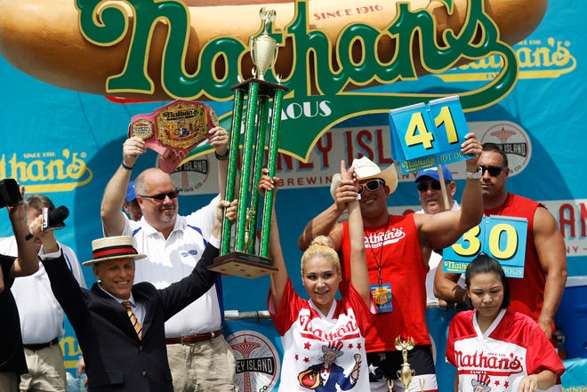 Miki Sudo grabs her fourth Nathan's Famous Hotdog eating contest win in the women's division on Tuesday, July 4, 2017, in the Brooklyn borough of New York. Sudo won after eating 41 hotdogs and buns. (AP Photo/Michael Noble Jr.)