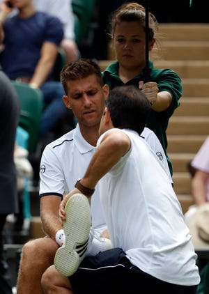 Slovakia’s Martin Klizan receives medical attention during his Men’s Singles Match against Serbia’s Novak Djokovic on day two at the Wimbledon Tennis Championships in London Tuesday, July 4, 2017. (AP Photo/Alastair Grant)