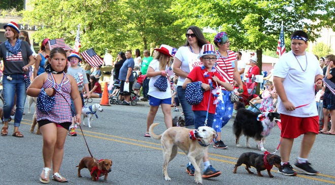 Members of the Bow Wow Brigade march with their pooches in the Great American Parade in Hillsdale. [NANCY HASTINGS PHOTO]