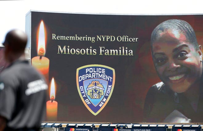 A security guard stands at attention as New York Police Department officer Miosotis Familia is memorialized before the start of a baseball game between the New York Yankees and the Toronto Blue Jays in New York Wednesday. Familia was killed in an "unprovoked attack," in the Bronx borough of New York, according to the NYPD Commissioner.