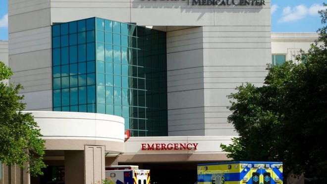 Ambulances pull up at the emergency room of the North Austin Medical Center.