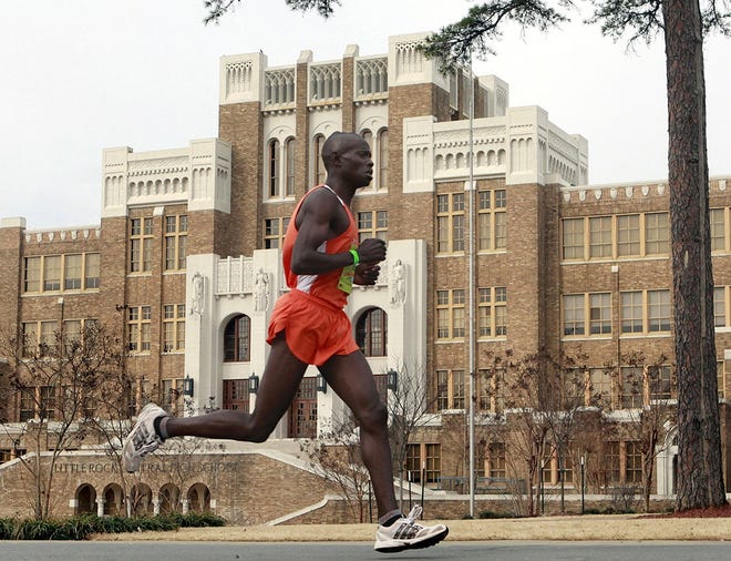 FILE - In this March 7, 2010, file photo, Moninda Marube runs past Little Rock Central High during the Little Rock Marathon race in Little Rock, Ark. Marube, of Kenya, says he had to outrun two charging bears while training in the woods Wednesday, July 5, 2017, near his home in Auburn, Maine. (AP Photo/Russell Powell, File)