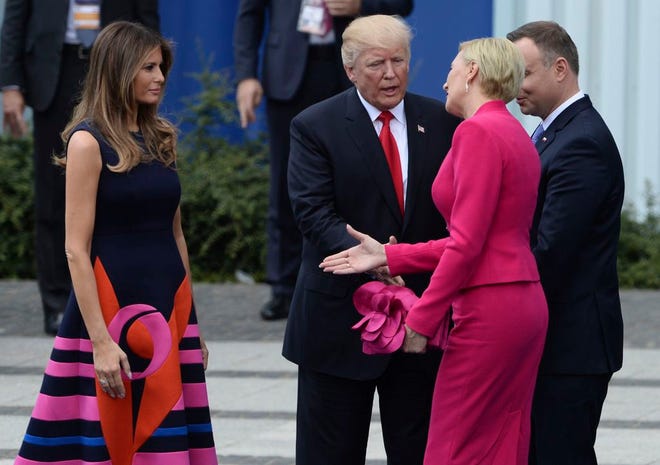 Poland's first lady Agata Kornhauser-Duda, second right, reaches her hand to U.S. First Lady Melania Trump as U.S. President Donald Trump reaches his hand for a handshake after his speech in Krasinski Square, with Polish President Andrzej Duda standing right, in Warsaw, Poland, Thursday, July 6, 2017. (AP Photo/Alik Keplicz)