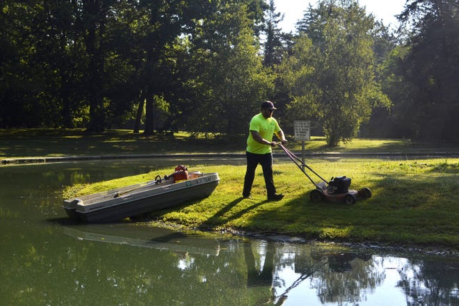 Ross Allsup, a seasonal employee for the Burlington Parks and Recreation Department, mows Thursday the small island on Crapo Park’s Lake Starker.