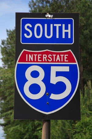 Interstate I-85 south sign and logo on roadside.