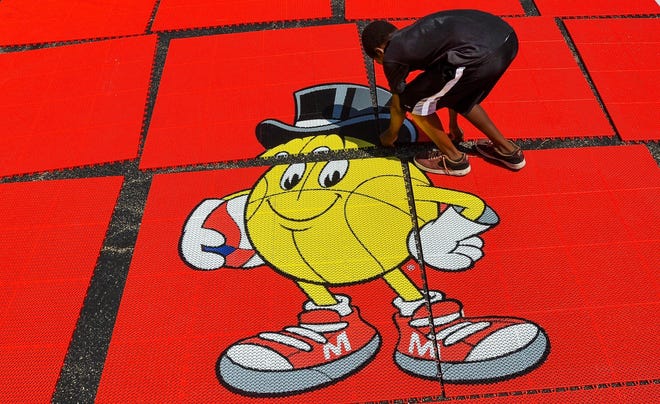 Twelve-year old Lamarkee Edwards of Peoria helps in the setup of one of the courts for the 2016 Gus Macker 3-on-3 basketball tournament at the Northwoods Community Church parking lot on North Allen Road. RON JOHNSON/JOURNAL STAR FILE PHOTO