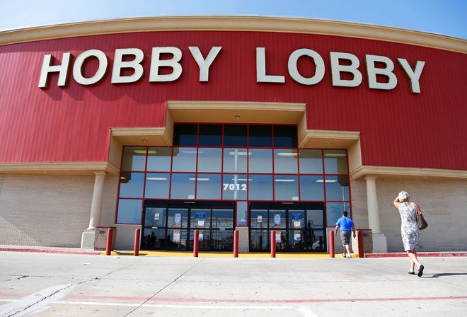 In this June 30, 2014, file photo, customers walk to a Hobby Lobby store in Oklahoma City. Federal prosecutors say Hobby Lobby Stores has agreed to pay a $3 million federal fine and forfeit thousands of ancient Iraqi artifacts smuggled from the Middle East that the government alleges were intentionally mislabled. Prosecutors filed a civil complaint in New York on Wednesday in which Oklahoma City-based Hobby Lobby consented to the fine and forfeiture of thousands of tablets and bricks written in cuneiform, one of the earliest systems of writing, as well as other artifacts that prosecutors say were shipped without proper documentation.