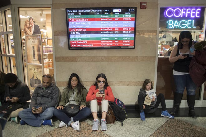 FILE- In this April 14, 2017 file photo, evening rush hour commuters wait for trains sitting under the departures board announcing that all trains are on stand by at Penn Station in New York while a New Jersey Transit train with about 1,200 passengers aboard was stuck in a Hudson River tunnel between New York and New Jersey. With major repairs starting Monday, July 10 that will disrupt schedules and create what New York Gov. Andrew Cuomo termed a "summer of hell" for commuters, the nation's busiest train station has become the latest example of America's inability, or unwillingness, to address its aging infrastructure. (AP Photo/Mary Altaffer, File)
