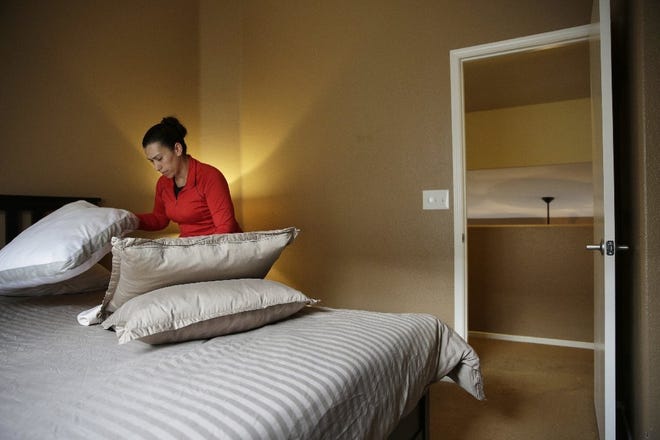 Jennifer Mesa cleans up a bedroom in the home of Randy Tussing, an Airbnb host, in preparation for guests in Las Vegas. Many cities, including Columbus, are considering ways to bring Uber-style home rentals under regulatory control like hotel and motel rooms. [The Associated Press File Photo]