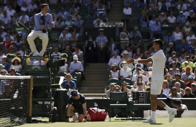 Serbia's Novak Djokovic gestures to umpire Jake Garner as he disputes a call in his third round singles match with Latvia's Ernests Gulbis on Saturday at the Wimbledon Tennis Championships in London. Djokovic won the match and hasn't lost a single set at this year's Wimbledon. [AP Photo/Tim Ireland]