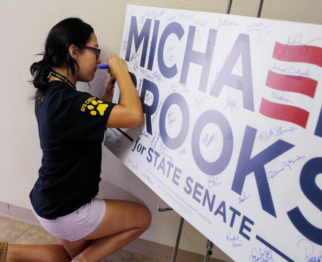 Marissa Hernandez signs a large campaign sign as volunteers gather to go door-to-door Saturday, July 8, 2017, in support of Democratic candidate Michael Brooks' Special Senate District 44 election against Republican Joe Griffin in Oklahoma City, Okla. Photo by Paul Hellstern, The Oklahoman