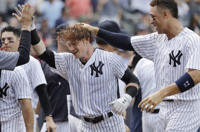 New York Yankees' Clint Frazier, center, is congratulated by teammates, including Aaron Judge, right, after hitting a three-run walkoff home run during the ninth inning against the Milwaukee Brewers on Saturday at Yankee Stadium. The Yankees won 5-3. [AP Photo/Julio Cortez]