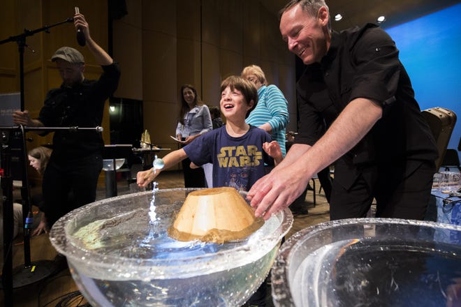 Joseph Krygier, a percussionist and lecturer at Ohio State University, gives a demonstration to a boy as part of an April water-themed concert by the New Albany Symphony. [JACK GARNER]