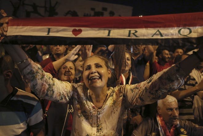 Iraqis in Baghdad's Tahrir Square celebrate the news that their nation's military foces have defeated IS in Mosul and taken control of the city. [AP Photo / Karim Kadim]