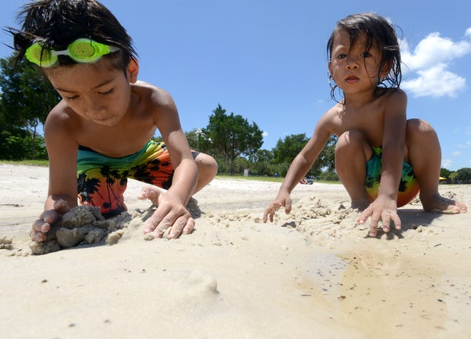 Siblings Edward and Elan Romero play in the sand at Waterfront Park on Monday in Clermont. [AMBER RICCINTO / DAILY COMMERCIAL]