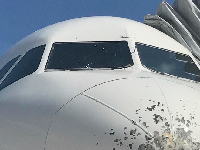 Cracks in a windshield and chipped paint can be seen on the front of an Airbus 320 from Atlanta to Port-Au-Prince, Haiti. The aircraft had to divert to Daytona Beach International Airport. [Volusia County Professional Firefighters Association]