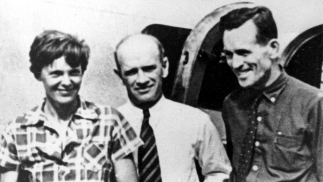 American aviator Amelia Earhart, left, and her navigator, Fred Noonan, right, pose beside their plane with gold miner F.C. Jacobs on or around July 2, 1937, at Lae, New Guinea. (Associated Press, file)