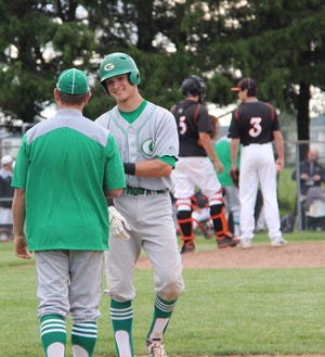 Keaton Rice fist bumps first base coach Jayme Farrell after drawing a walk in the Class 3A Regional Semifinal game. Rice was selected the IHSBCA 3A All-State Team.