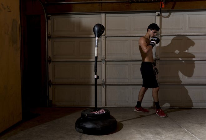 Ryan Garcia takes a break while training his garage, converted into a boxing gym. Garcia, of Victorville, is scheduled to fight Mario Antonio Macias at the Forum, in Inglewood, on Saturday. [James Quigg, Daily Press]