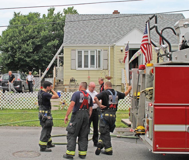 East Providence firefighters finish knocking down a house fire at 43 Reynolds St. on Tuesday. [The Providence Journal / Steve Szydlowski]