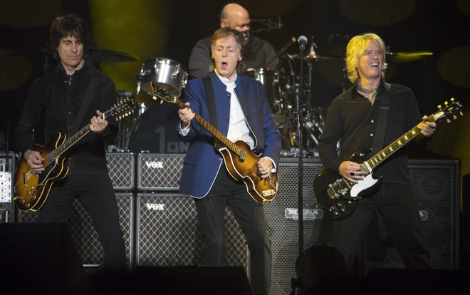 Paul McCartney, center, performed a nearly three-hour, 40-song set at Amalie Arena in Tampa on Monday. [AP PHOTO / SCOTT AUDETTE]
