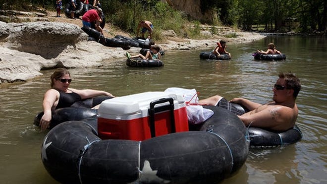 Amy Mountain (left) and Felix Savala, both of Houston, float down the Guadalupe River in Canyon Lake, Texas, on Thursday, June 23, 2011. On vacation, the pair rented their tubes from River Sport Tubes. "I'm looking for some cold water and cold beer," Savala said.
