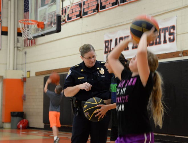 Stoughton Police Chief Donna McNamara teaches students to play basketball at Stoughton High School during the Norfolk District Attorney's basketball camp Wednesday.