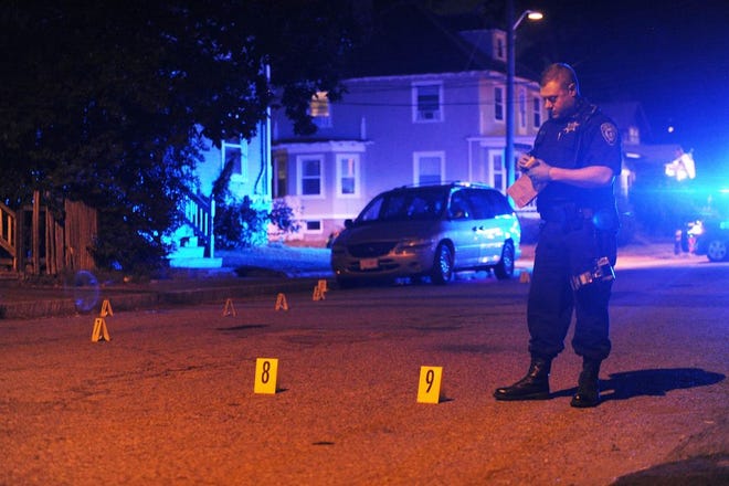 A deputy with the Plymouth County Bureau of Criminal Investigation documents evidence where shell casings were found on Hillberg Avenue, Monday, July 10, 2017, after about 10 shots were fired in Brockton.