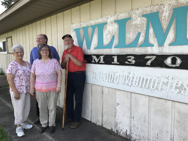 Standing in front of the WLLM sign in Lincoln are Zelma Martin, Bill Dolan, Pam Pollard and Daris Knauer who are supporting the effort to bring back Christian radio to Lincoln. [Photo by Jean Ann Miller/The Courier]