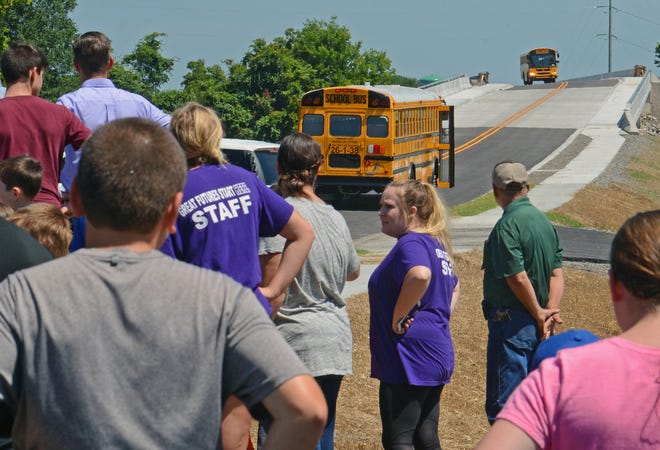 Alma school buses travel on the new section of Arkansas 162 in Alma during a bridge dedication and ribbon cutting on Tuesday, July 11, 2017. The bridge overpass was dedicated in honor of the late Marsha Woolly. [BRIAN D. SANDERFORD/TIMES RECORD]