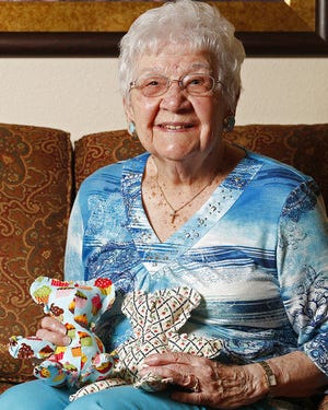 Edith Kroencke, 99, is shown June 23 holding two teddy bears she stuffed at Curtis Creek Senior Living in Quincy, Ill. To keep herself busy, Kroencke uses donated fabric to sew and stuff teddy bears for children at Blessing Hospital. Kroencke recently delivered her monthly quota of 30 bears to Blessing for the month of June.
