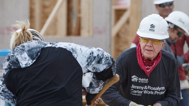Former President Jimmy Carter and a volunteer help build stairs for a homes for Habitat for Humanity in Edmonton Alberta, Tuesday July 11, 2017. (Jason Franson/The Canadian Press via AP)