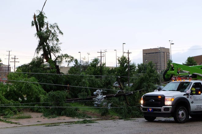 Westar Energy, the Topeka Fire Department and the Topeka Police Department responded to the 900 block of S.E. Jefferson where a tree had fallen on a light pole, causing outages in the area. (Katie Moore/The Capital-Journal)