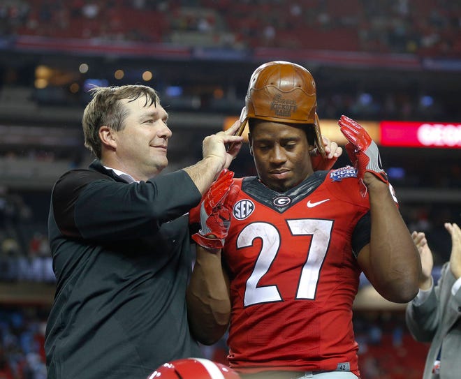 Georgia head coach Kirby Smart puts the “Old Leather Helmet” on running back Nick Chubb’s head after an NCAA college football game against North Carolina in Atlanta, Saturday, Sept. 3, 2016. Georgia won 33-24. The helmet is part of a trophy awarded to the winner of the Chick-fil-A Kickoff Game. (AP Photo/John Bazemore)