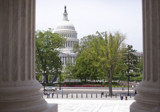 The Capitol building is seen through the columns on the steps of the Supreme Court in Washington.