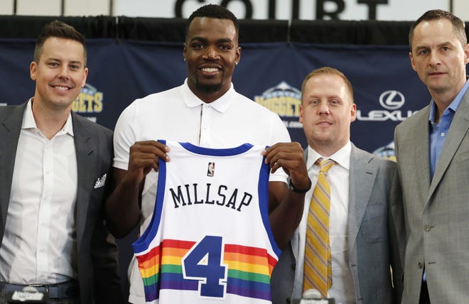 FILE - In this July 13, 2017, file photo, Denver Nuggets new NBA basketball forward Paul Millsap, second from left, holds up his new jersey as Josh Kroenke, team president and governor, left, Tim Connelly, president of basketball operations and Arturas Karnisovas, general manager of the Nuggets, join in for a photograph during Millsap's introduction to the media at a news conference in Denver. [AP Photo/David Zalubowski, File]