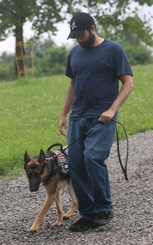 Army veteran Steve Covert, from Conneaut, works with his dog Glock at the Dogs 4 Warriors compound near Bowerston in Harrison County. Covert served a tour of duty in Iraq and two tours of duty in Afghanistan. (TimesReporter.com / Jim Cummings)