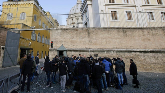 In this 2015 file photo, Italian journalists Gianluigi Nuzzi and Emiliano Fittipaldi talk to reporters outside the Vatican City from the Perugino gate. (AP Photo/Gregorio Borgia, File)