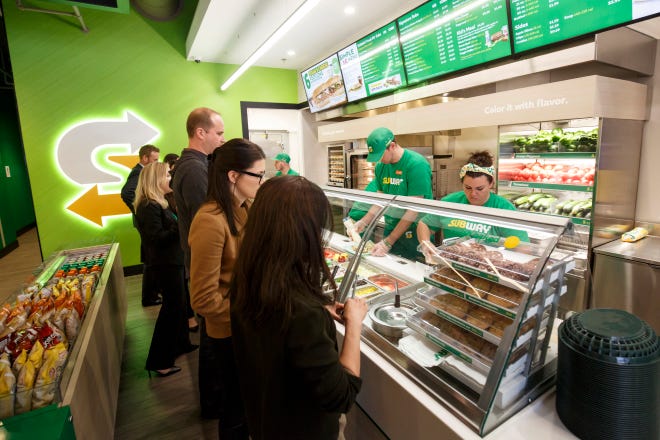This January 2017 photo provided by Subway shows the interior of a remodeled Subway store in Knoxville, Tenn. Subway is looking to update the look of its stores as the chain's U.S. sales have been declining. The company says the redesign, which includes a brighter atmosphere, displays of vegetables behind the counter and ordering tablets, is the first major revamp since the early 2000s. [Chris Radcliffe/Subway via AP]