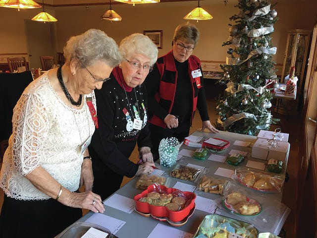 (Left to right) Darlene Pitsenbarger, Florence Heck and Marilyn Bode check on their bids at a silent auction that supports the Nu Alpha Gamma scholarships. PHOTO CONTRIBUTED TO THE CHIEF