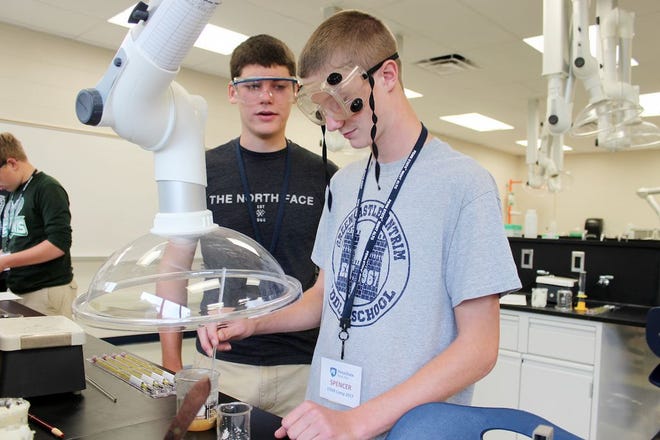 Greencastle students Spencer Woodring, right, and Collin Miller stir the ingredients to make soap in Penn State Mont Alto’s chemistry lab during last week’s STEM Camp.
