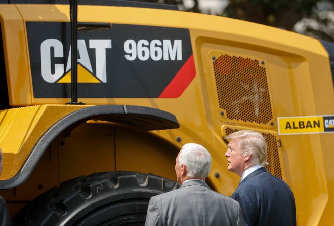 President Donald Trump and Vice President Mike Pence stop to looks at a Caterpillar truck, manufactured in Illinois, on the South Lawn of the White House in Washington, Monday, July 17, 2017, during a "Made in America," product showcase featuring items created in each of the U.S. 50 states. (AP Photo/Pablo Martinez Monsivais)