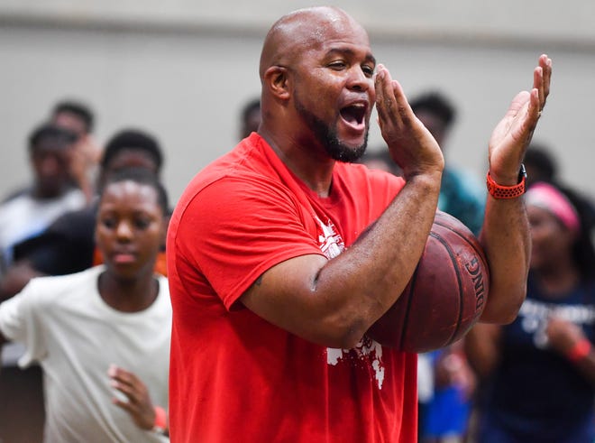 RON JOHNSON/JOURNAL STAR Frankie King, a coach at the Mitchell JJ Anderson/Dana Davis Basketball Camp at the Peoria Civic Center gives student a hand during practice on Tuesday.