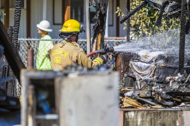Firefighters from Goshen mop up an early morning fire that destroyed three homes in the Bella Casa Mobile Home Park off of Edenvale Rd. in Pleasant Hill on Monday. One person was injured and transported to Riverbend Hospital. The fire began around 4:30 a.m. and was under control by 5:45 a.m. (Rhianna Gelhart/The Register-Guard)
