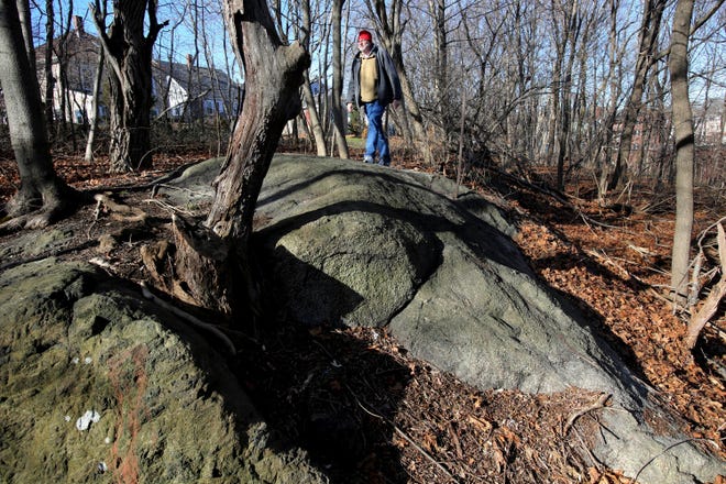 FILE - In this Jan. 11, 2016 file photo, Salem State University history professor Emerson Baker walks through an area known as Proctor's Ledge that he and a team of researchers said is the exact site where innocent people were hanged during the 1692 witch trials in Salem, Mass. Salem and Danvers are holding separate ceremonies Wednesday, July 19, 2017, to mark the 325th anniversary of the hangings of five women convicted of being witches. Twenty people in all were killed. (Ken Yuszkus/The Salem News via AP, File)
