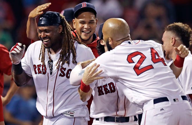 Hanley Ramirez (left) and the Red Sox celebrate after Ramirez hit a walk-off home run in the 15th inning to give Boston a 5-4 win over the Blue Jays on Tuesday night at Fenway Park.