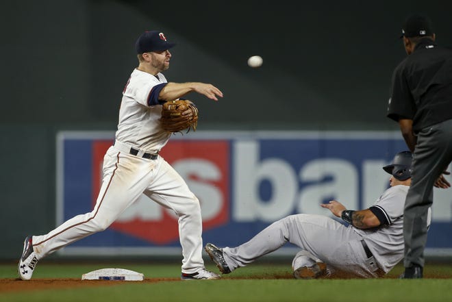 Minnesota Twins second baseman Brian Dozier throws to first after forcing out New York Yankees' Gary Sanchez during the ninth inning of a MLB game. [AP Photo/Bruce Kluckhohn]